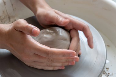 Polonya 'da modern sanat seramik atölyesinde atölye çalışması sırasında çömlekçi çarkında çamur tenceresi yapmak