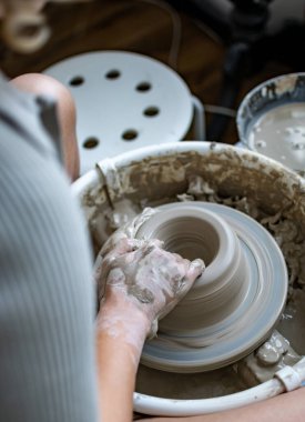 Polonya 'da modern sanat seramik atölyesinde atölye çalışması sırasında çömlekçi çarkında çamur tenceresi yapmak