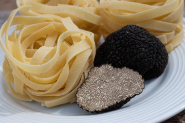 İtalyan yemeği, mantarlı tagliatelle makarna, lezzetli aromalı mantar yapmak için taze siyah mantar mantarı, vejetaryen yemeği.