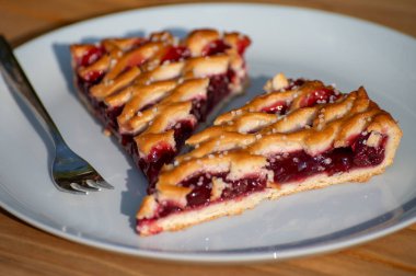 Ev yapımı ekşi vişneli turta, lezzetli tatlı, açık havada, güneşli bahçede servis ediliyor.