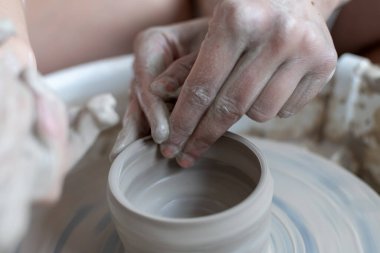 Polonya 'da modern sanat seramik atölyesinde atölye çalışması sırasında çömlekçi çarkında çamur tenceresi yapmak