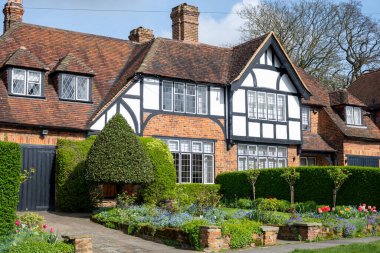 Kuzey Londra sokaklarında yürümek, baharda kırmızı tuğlalı evler ve çiçek açan bahçeler, şehir hayatı, Mart ayında Londra, İngiltere 'de zengin mahalleler.