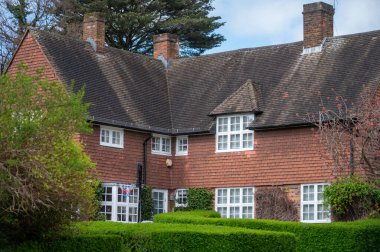 Kuzey Londra sokaklarında yürümek, baharda kırmızı tuğlalı evler ve çiçek açan bahçeler, şehir hayatı, Mart ayında Londra, İngiltere 'de zengin mahalleler.