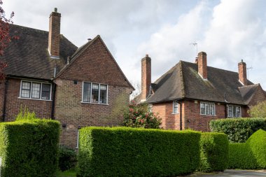 Kuzey Londra sokaklarında yürümek, baharda kırmızı tuğlalı evler ve çiçek açan bahçeler, şehir hayatı, Mart ayında Londra, İngiltere 'de zengin mahalleler.