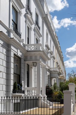 Notting Hill, baharda beyaz evler ve çiçek açan bahçelerle sokaklarda yürümek, şehir hayatı, ilkbaharda Londra, İngiltere 'de varlıklı mahalleler.