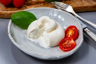 Taze İtalyan peyniri, beyaz burrata topları ya da mozzarella ve kremadan yapılmış burratina peyniri yemek.