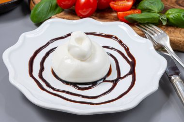 Taze İtalyan peyniri yemek, beyaz burrata topları ya da mozzarella ve kremadan yapılmış burratina peyniri yemek ya da Modena 'dan gelen balzamik krem sirkeyle servis edilen gorgonzola.