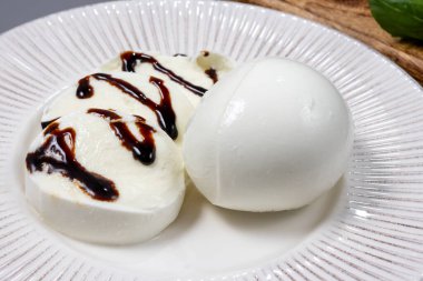 Lezzetli İtalyan yemekleri, taze beyaz bufalo sütü mozzarella yumuşak peynir topları Campania 'dan gelen balzamik sirkeyle servis ediliyor.