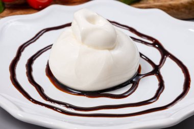 Taze İtalyan peyniri yemek, beyaz burrata topları ya da mozzarella ve kremadan yapılmış burratina peyniri yemek ya da Modena 'dan gelen balzamik krem sirkeyle servis edilen gorgonzola.