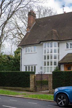 Kuzey Londra sokaklarında yürümek, baharda kırmızı tuğlalı evler ve çiçek açan bahçeler, şehir hayatı, Mart ayında Londra, İngiltere 'de zengin mahalleler.