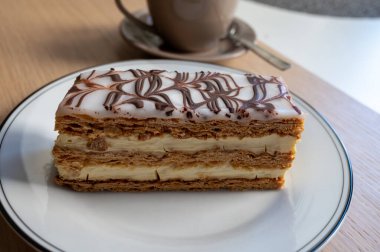 Portion of french mille-feuille cake, vanilla or custard slice, Napoleon puff pastry layered with pastry cream in French bakery clipart