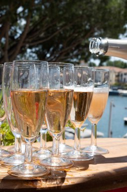 Fransız brut şampanyası şampanya köpüklü lale kadehleri ile Saint-Tropez yakınlarındaki Port Grimaud limanında, Fransız Riviera tatili, Var, Fransa yaz tatili