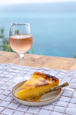 Provence 'de yaz mevsimi, bir bardak soğuk gül şarabı ve arka planda mavi deniz manzaralı tatlı, Fransa' nın güneyinde Monako ve Menton yakınlarında Fransız Rivierası.