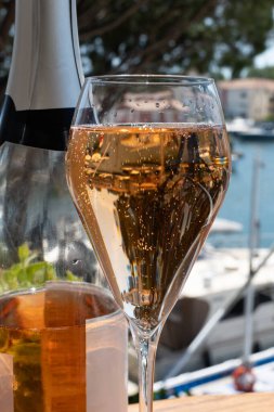 Fransız brut şampanyası şampanya köpüklü lale kadehleri ile Saint-Tropez yakınlarındaki Port Grimaud limanında, Fransız Riviera tatili, Var, Fransa yaz tatili