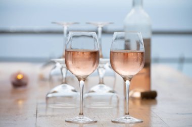 Summer time in Provence, two glasses of cold rose wine with blue sea view on background, French Riviera near Menton and Monaco, south of France clipart