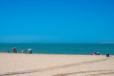 Sanlucar de Barrameda 'daki Qudalquivir nehrinin altın kumlu plajları ve gezinti güvertesi, küçük Endülüs kasabası, İspanya yazın