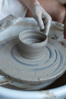 Polonya 'da modern sanat seramik atölyesinde atölye çalışması sırasında çömlekçi çarkında çamur tenceresi yapmak