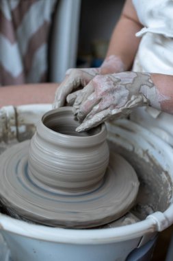 Polonya 'da modern sanat seramik atölyesinde atölye çalışması sırasında çömlekçi çarkında çamur tenceresi yapmak