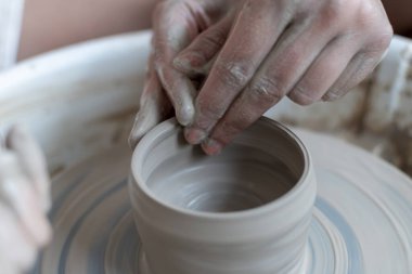 Polonya 'da modern sanat seramik atölyesinde atölye çalışması sırasında çömlekçi çarkında çamur tenceresi yapmak