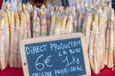 Souillac, Dordogne, Fransa 'daki yerel çiftçi pazarında satılık taze çiğ, pembe kuşkonmaz sebzeleri. İngilizce çeviri: Payrignac 'ta yerel üretilen 1 kg deste