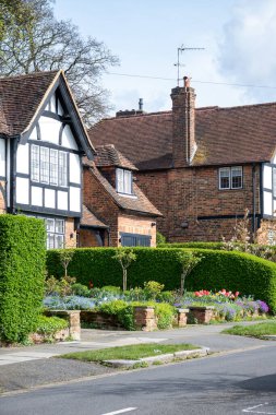 Kuzey Londra sokaklarında yürümek, baharda kırmızı tuğlalı evler ve çiçek açan bahçeler, şehir hayatı, Mart ayında Londra, İngiltere 'de zengin mahalleler.