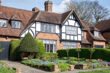 Kuzey Londra sokaklarında yürümek, baharda kırmızı tuğlalı evler ve çiçek açan bahçeler, şehir hayatı, Mart ayında Londra, İngiltere 'de zengin mahalleler.