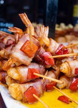 Typical snacks of Basque Country, pinchos or pinxtos skewers with small pieces of bread, fish, sea food, sweet green pepper served in bar in San-Sebastian or Bilbao, Spain, close up clipart