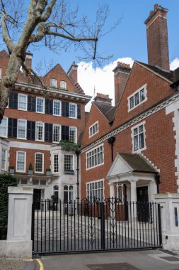 Kensington ve Chelsea Kraliyet Borough 'daki Hans Crescent caddesindeki kırmızı tuğlalı evler, Londra, İngiltere. Baharda