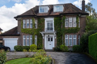 Kuzey Londra sokaklarında yürümek, baharda kırmızı tuğlalı evler ve çiçek açan bahçeler, şehir hayatı, Mart ayında Londra, İngiltere 'de zengin mahalleler.