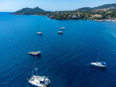 Mavi Akdeniz 'deki panoramik manzara, Agay kasabasının kumlu plajı, Esterel kızıl dağları yakınlarındaki yaz tatili merkezi, Fransız Riviera, Provence. Fransa