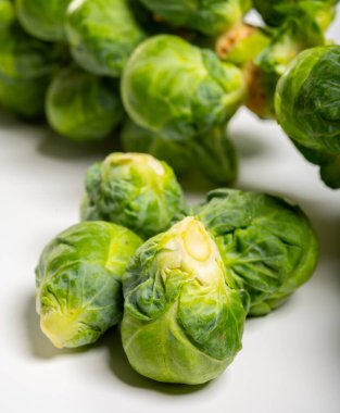 Yeşil Brüksel lahanası, beyaz masanın saplarında sebzeler filizlenir.