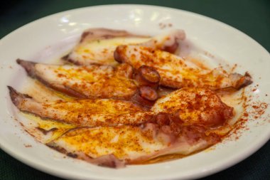 Geleneksel Endülüs yemeği pulpo ahtapot deniz ürünleri eski tavernada tapa olarak kırmızı pimento paprika ile servis edilir, Sanlucar de Barrameda, İspanya