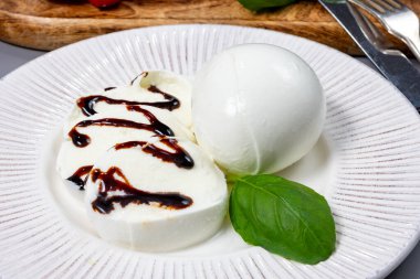 Lezzetli İtalyan yemekleri, taze beyaz bufalo sütü mozzarella yumuşak peynir topları Campania 'dan gelen balzamik sirkeyle servis ediliyor.
