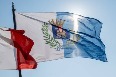 Terracina 'nın beyaz-mavi bayrağı, Civitas Terracina, İtalya, güneşli bir günde direkte sallanıyor.