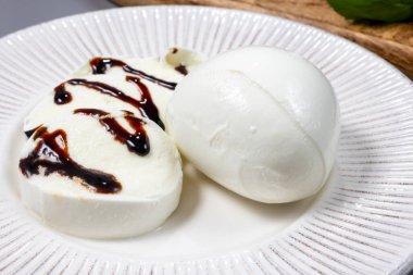Lezzetli İtalyan yemekleri, taze beyaz bufalo sütü mozzarella yumuşak peynir topları Campania 'dan gelen balzamik sirkeyle servis ediliyor.