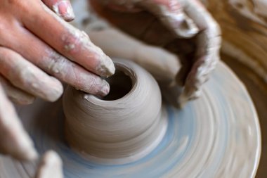 Polonya 'da modern sanat seramik atölyesinde atölye çalışması sırasında çömlekçi çarkında çamur tenceresi yapmak