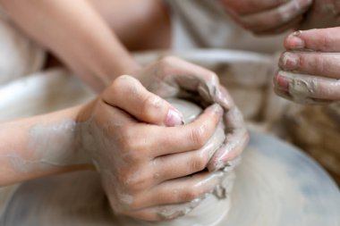 Polonya 'da modern sanat seramik atölyesinde atölye çalışması sırasında çömlekçi çarkında çamur tenceresi yapmak