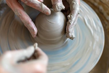 Polonya 'da modern sanat seramik atölyesinde atölye çalışması sırasında çömlekçi çarkında çamur tenceresi yapmak