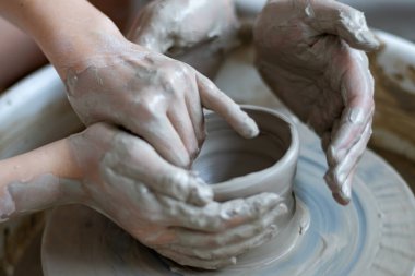 Polonya 'da modern sanat seramik atölyesinde atölye çalışması sırasında çömlekçi çarkında çamur tenceresi yapmak