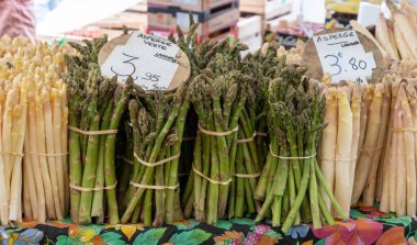 Fresh raw white and green asparagus vegetables for sale in local farmers market in Souillac, Dordogne, France. Translation: Fine asparagus from Landes, Green asparagus from Landes and prices per bunch clipart