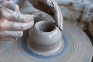 Polonya 'da modern sanat seramik atölyesinde atölye çalışması sırasında çömlekçi çarkında çamur tenceresi yapmak