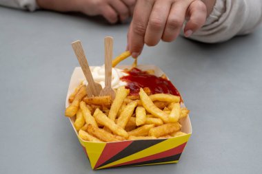 Belçika sokağı ve fast food, Belçika bayrağı renginde kağıt külah patates cipsi.