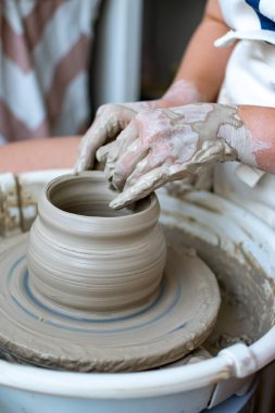 Polonya 'da modern sanat seramik atölyesinde atölye çalışması sırasında çömlekçi çarkında çamur tenceresi yapmak