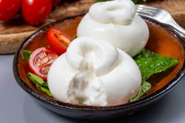 Taze İtalyan peyniri, beyaz burrata topları ya da mozzarella ve kremadan yapılmış burratina peyniri yemek.