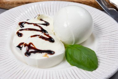 Lezzetli İtalyan yemekleri, taze beyaz bufalo sütü mozzarella yumuşak peynir topları Campania 'dan gelen balzamik sirkeyle servis ediliyor.