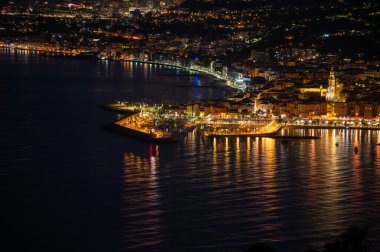 Night view on French Riviera, lights of Menton old city and marina on blue Mediterranean Sea near French-Italian border, Monaco, Monte-Carlo, travel destination, panoramic view seaside clipart