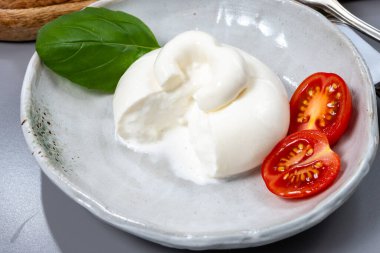 Taze İtalyan peyniri, beyaz burrata topları ya da mozzarella ve kremadan yapılmış burratina peyniri yemek.