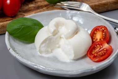 Taze İtalyan peyniri, beyaz burrata topları ya da mozzarella ve kremadan yapılmış burratina peyniri yemek.