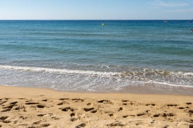 Cavalaire-sur-Mer ve La Croix-Valmer yakınlarındaki Plage du Debarquement beyaz kumlu sahilinde kristal berrak mavi su ve tekneler üzerinde sabah manzarası, Fransız Riviera, Var, Fransa 'da yaz tatili