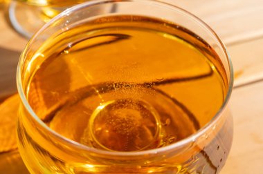 Güneşli bahçede yeni hasat edilmiş elmalardan yapılmış elma suyunun tadına bakmak, bir bardak elma şarabı.